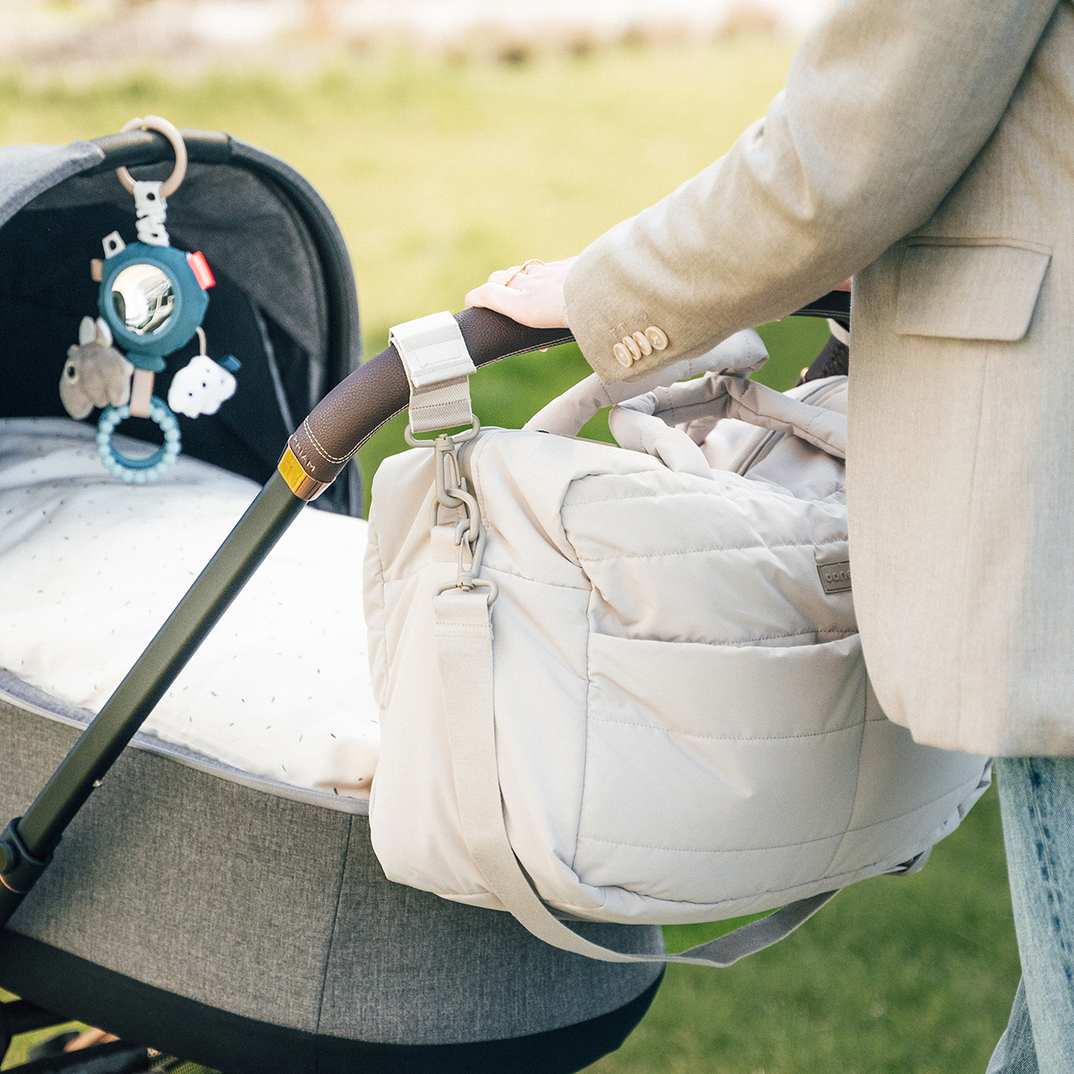 sac a langer Done by Deer sable fixé à une poussette avec sangles ajustables