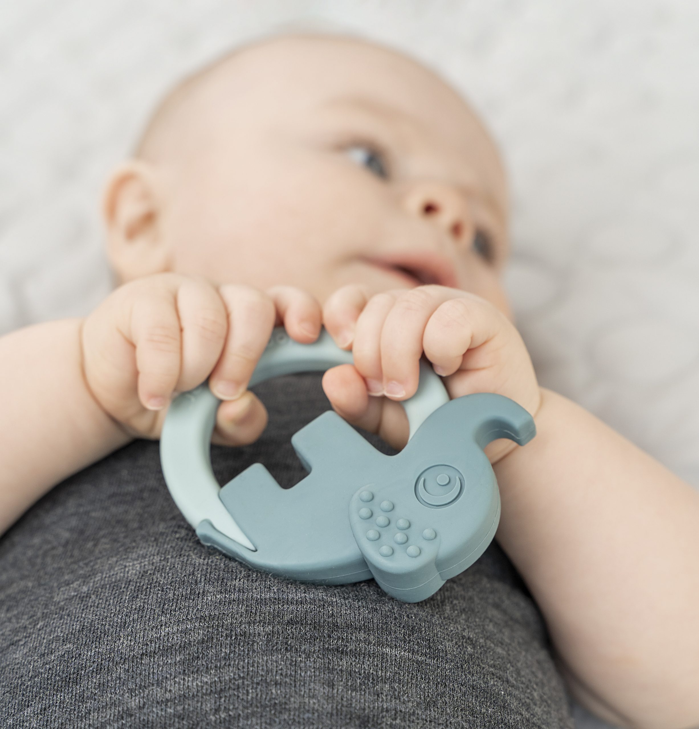 Bébé tenant un anneau dentition en silicone Done by Deer