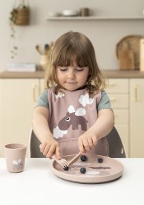 Enfant mangeant avec vaisselle Done By Deer