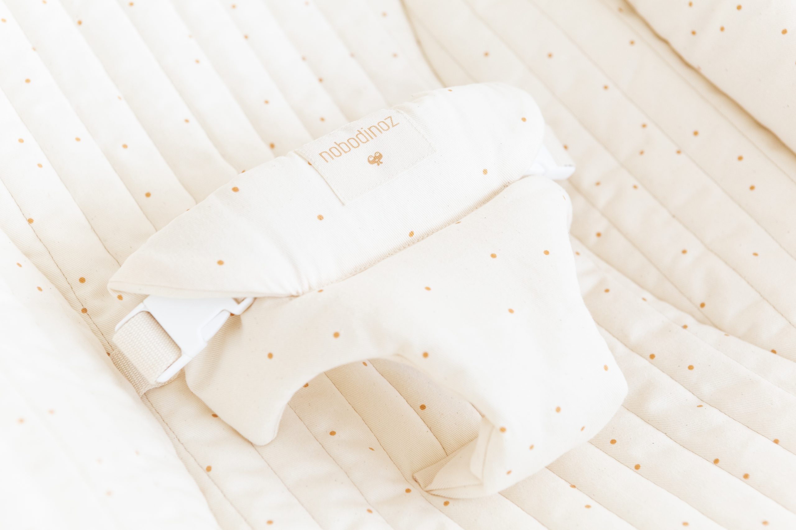 Détail de la ceinture ajustable du transat bébé Nobodinoz Growing Green Honey Sweet Dots.