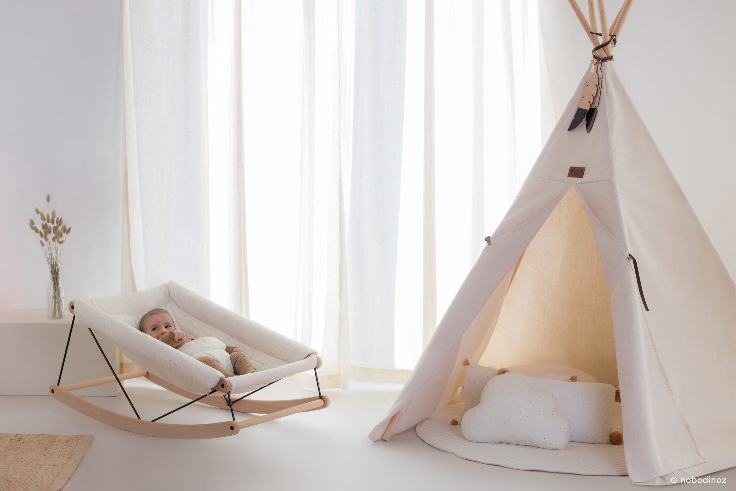 Bébé dans le transat Nobodinoz Growing Green Honey Sweet Dots, ambiance chambre naturelle.