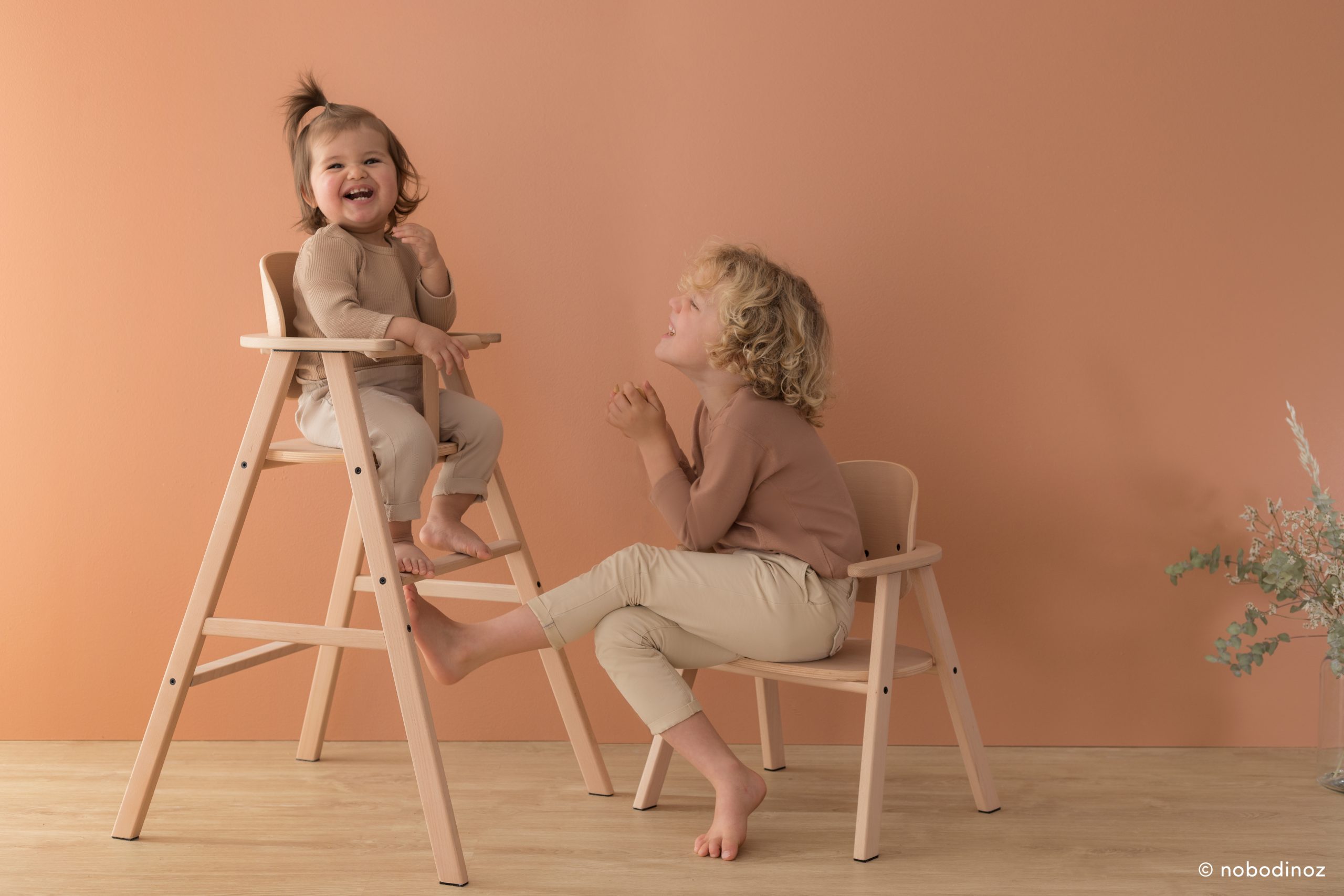 Enfants utilisant la chaise haute évolutive Nobodinoz en bois naturel.