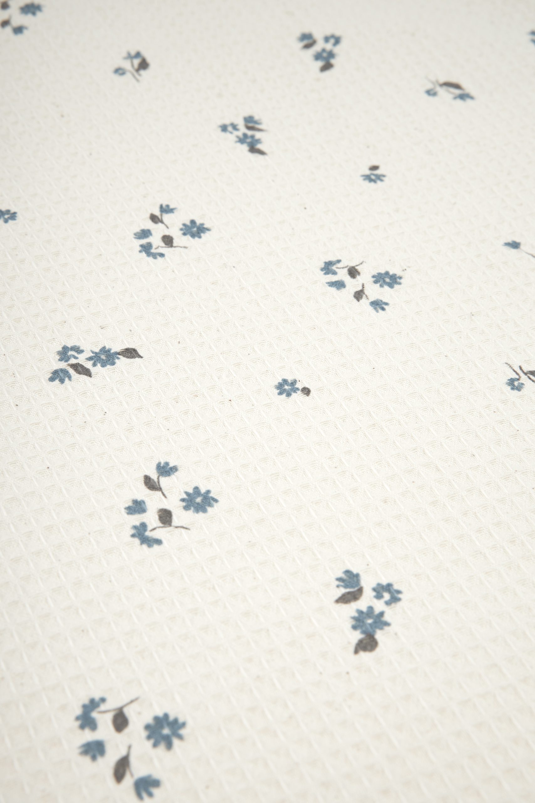 Motif fleuri bleu du tapis à langer nomade bébé Nobodinoz Mozart Lily Blue