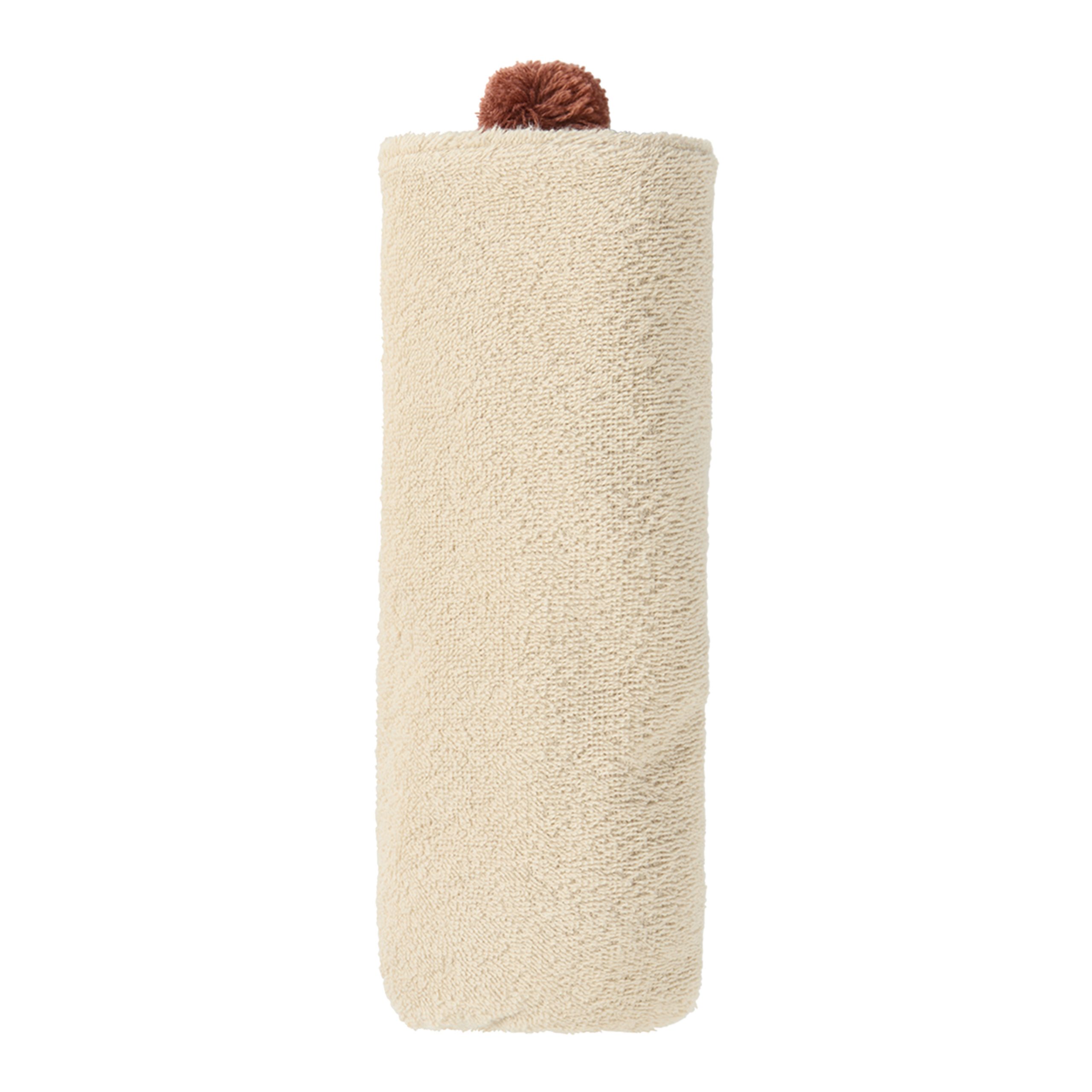 Cape de bain Nobodinoz en coton bio coloris Amande, roulée avec pompon sur le dessus.