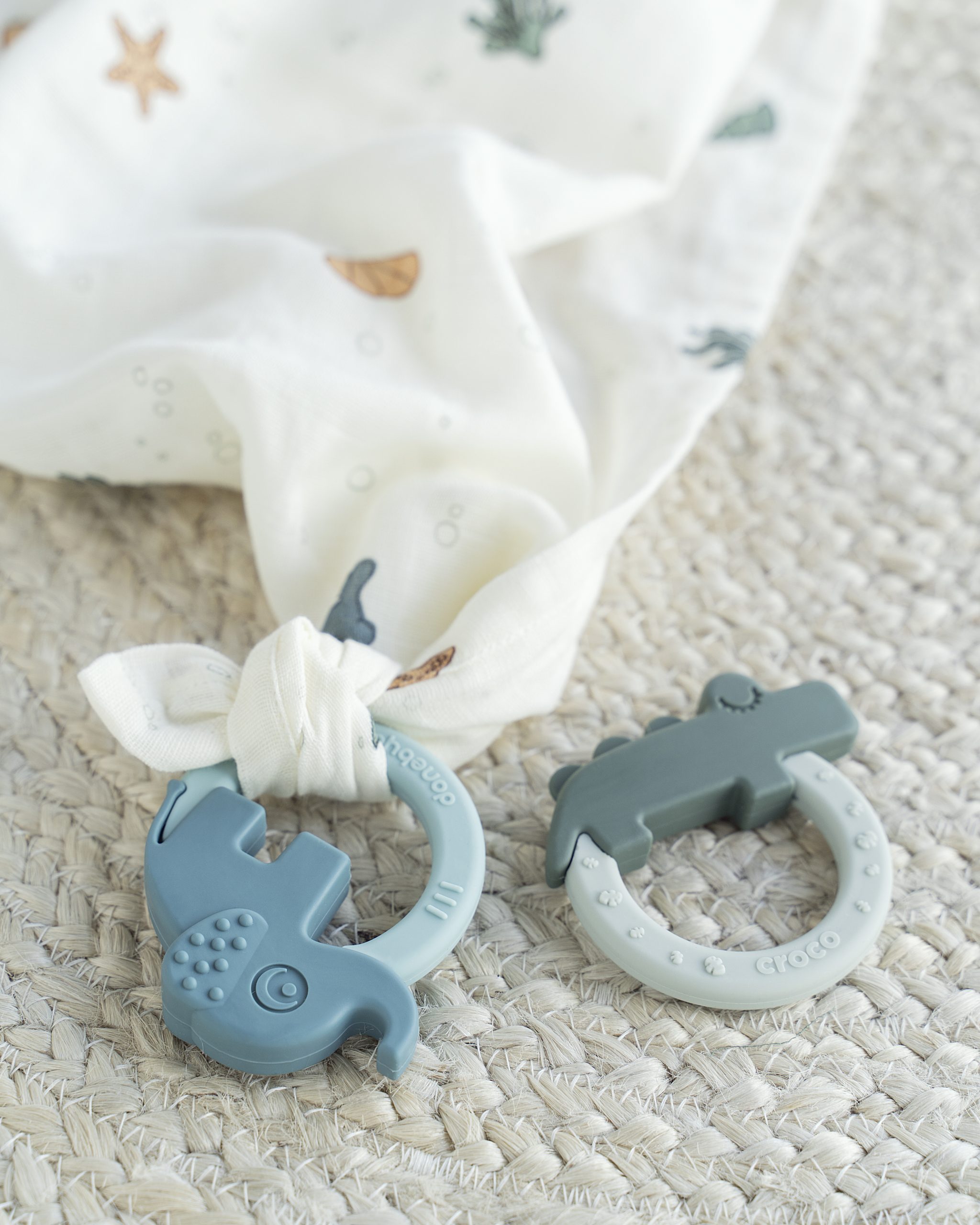 Anneaux dentition Done by Deer posés sur un lange bébé