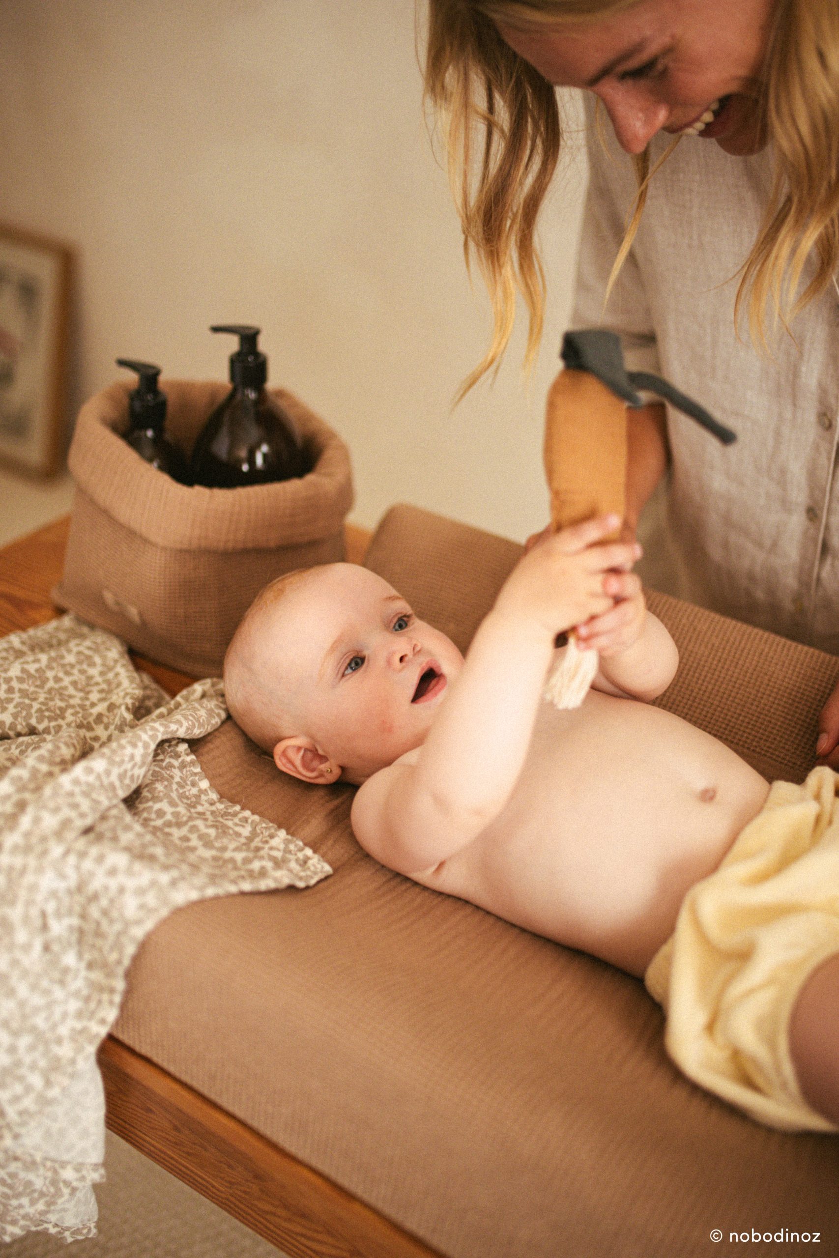 Panier de rangement Nobodinoz Wabi-Sabi Sésame sur une table à langer dans une chambre bébé