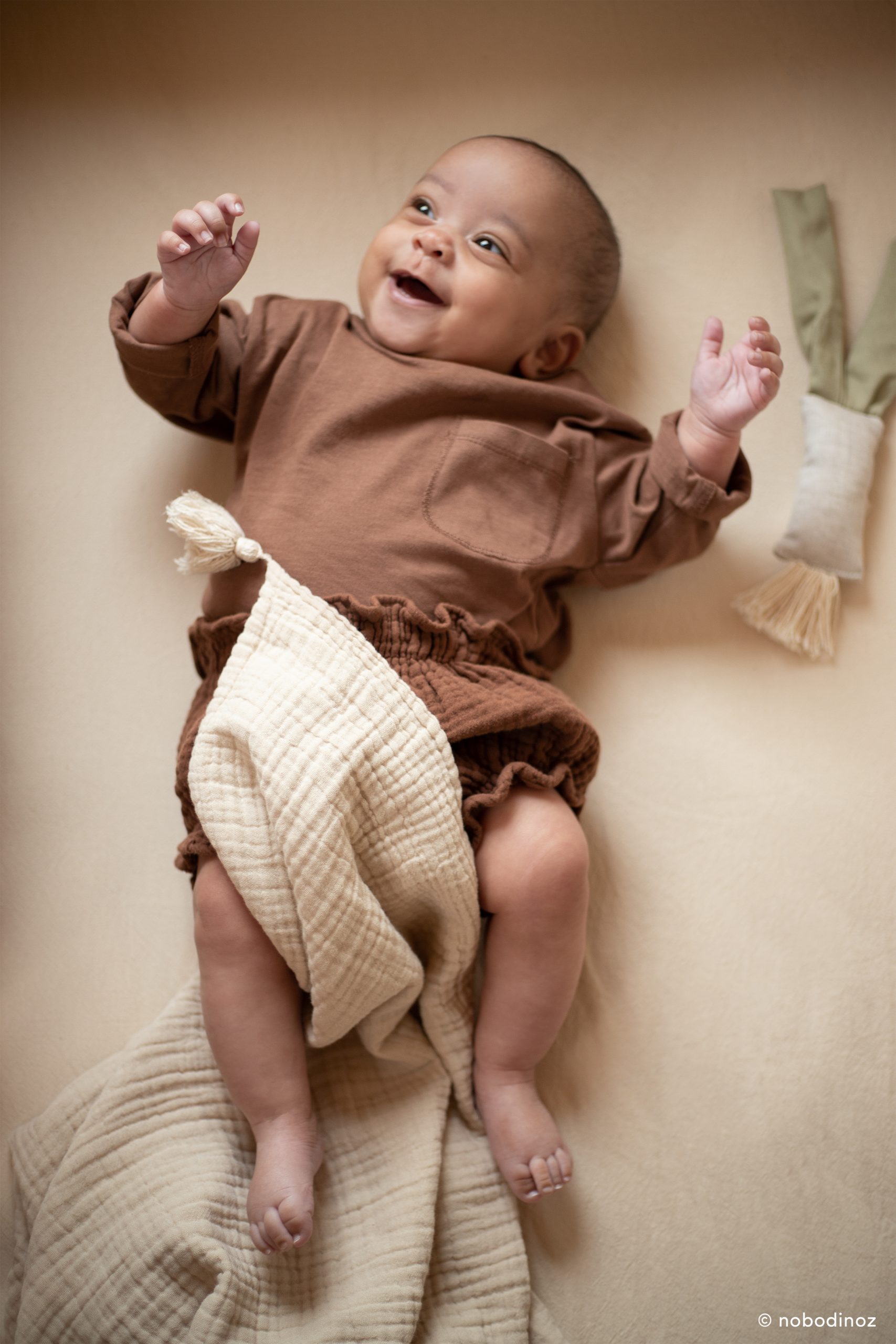 bébé jouant sur couverture bebe beige Nobodinoz coton doux