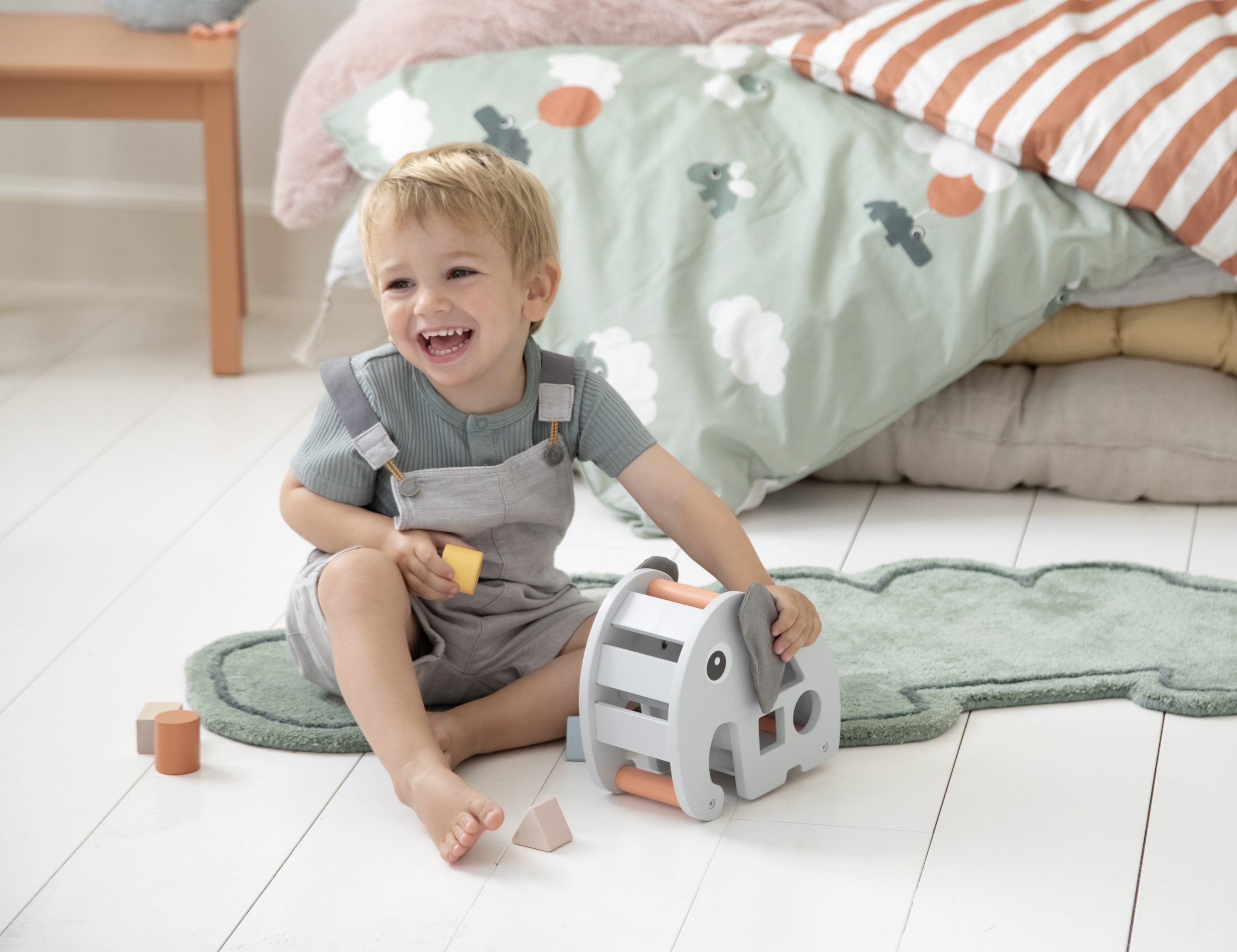 Enfant jouant avec le jeu à encastrer Elphée Done by Deer au sol.