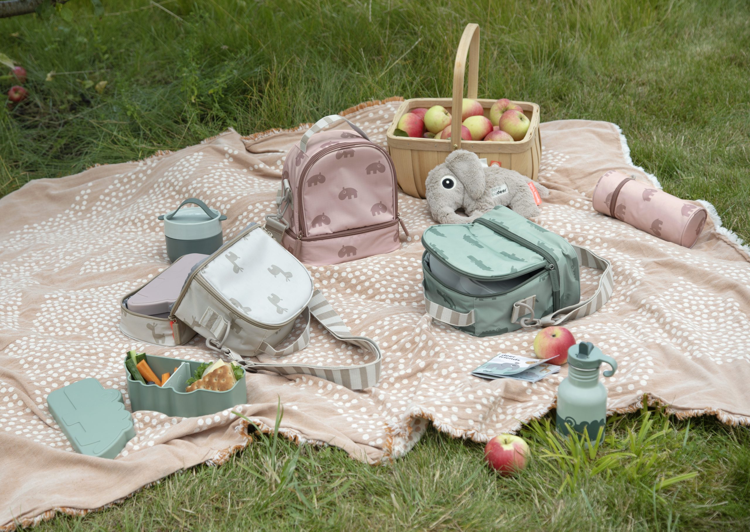 Collection Done by Deer Lalee avec sacs isothermes sable, vert et rose, gourde et boîte à lunch assorties.