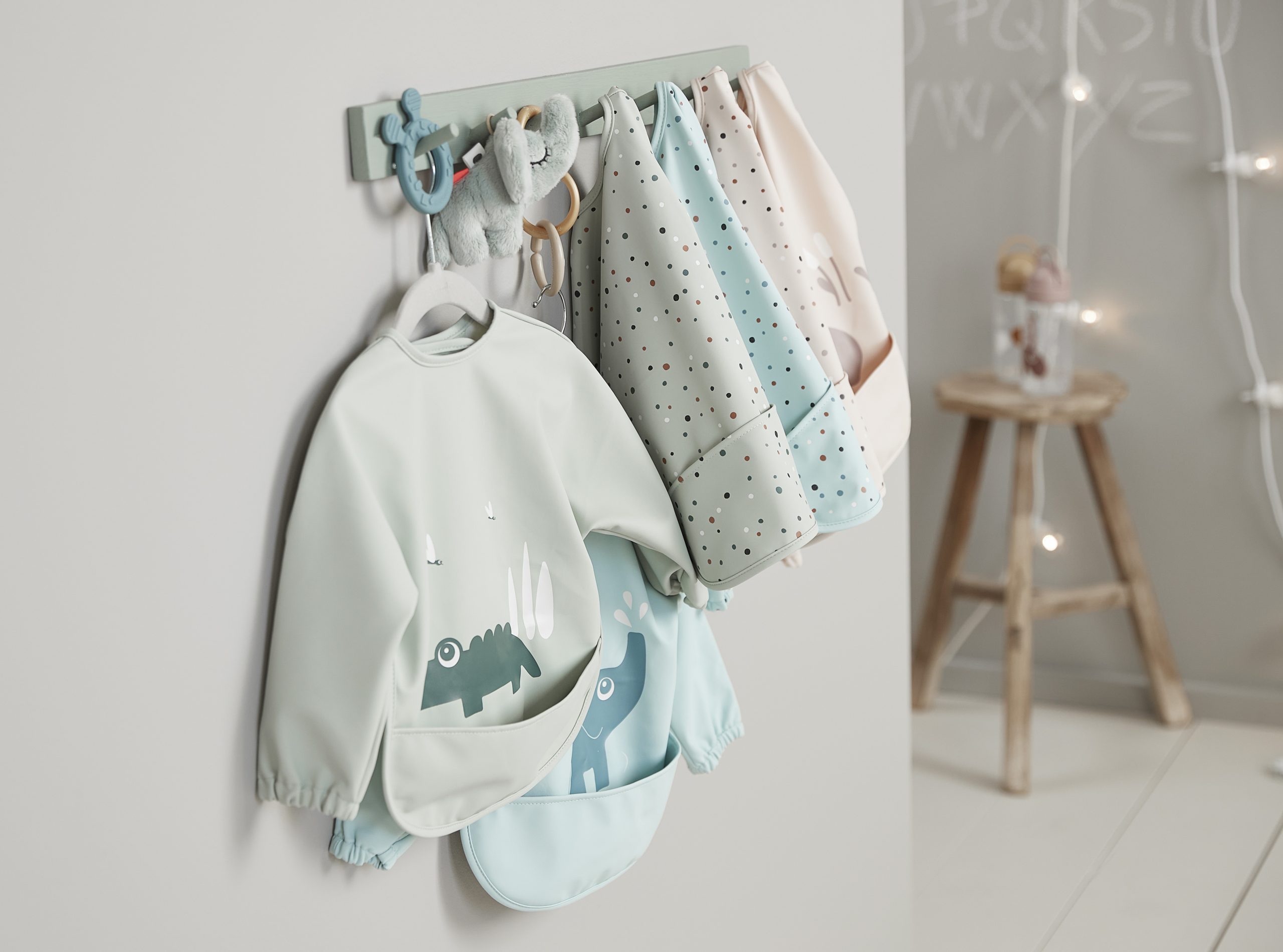 Bavoirs Done by Deer suspendus, dont le modèle Croco Vert, dans une chambre bébé au style nordique.