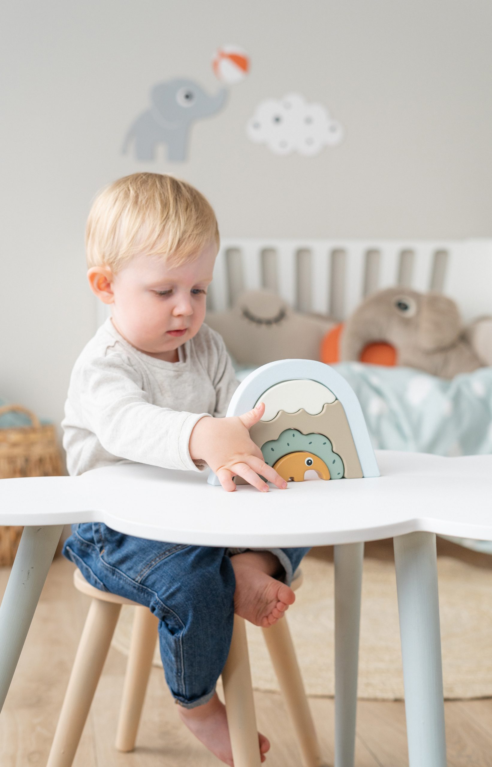 Petit garçon jouant avec l’arc à empiler Antee – Done by Deer – sur une table – jeu d’équilibre et de motricité – jouet en bois dès 12 mois