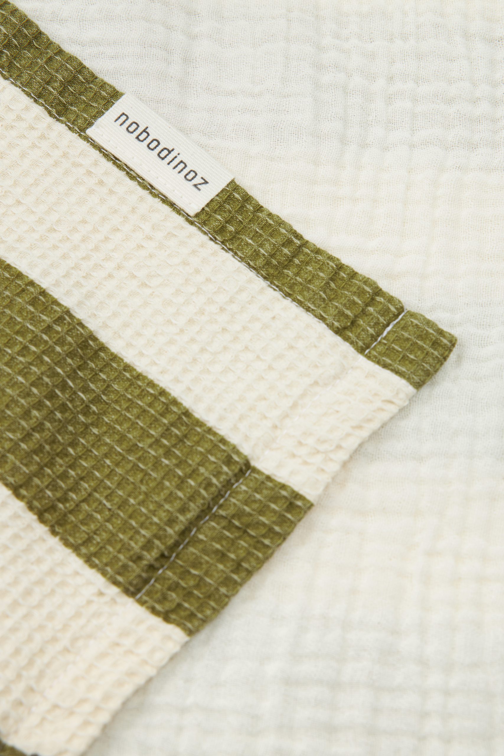 Détail du poncho de bain bébé vert Nobodinoz en coton bio nid d’abeille et gaze de coton