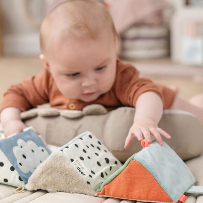 Bébé jouant avec des cubes sensoriels sur un tapis d'éveil, une belle idée de cadeau de naissance