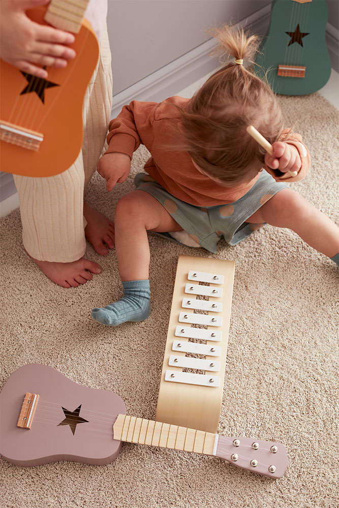Enfant jouant avec des instruments de musique en bois Kid’s Concept
