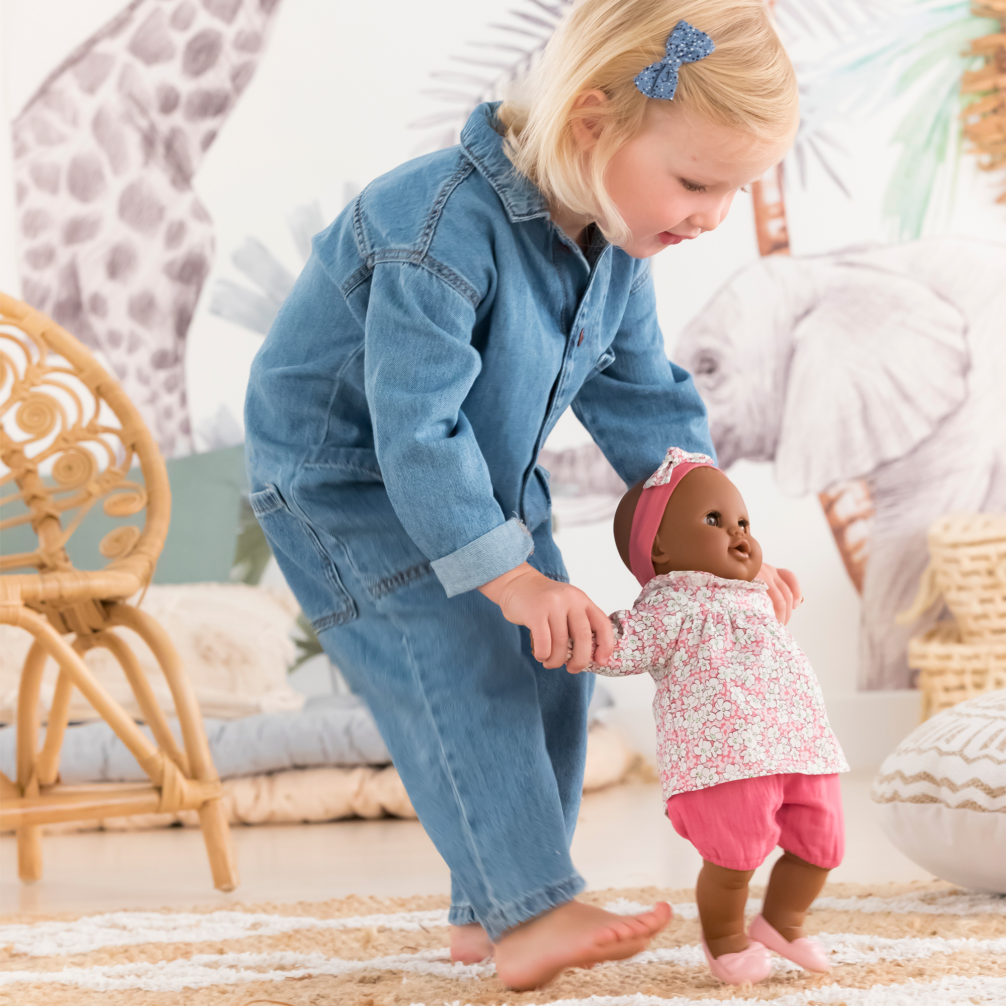 Enfant jouant avec le poupon Corolle Lilou 36 cm dans une chambre au décor naturel.
