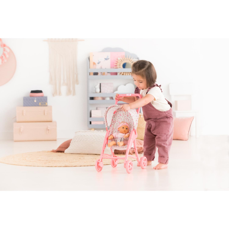 Enfant jouant avec une poussette Corolle rose fleurie et son poupon Corolle