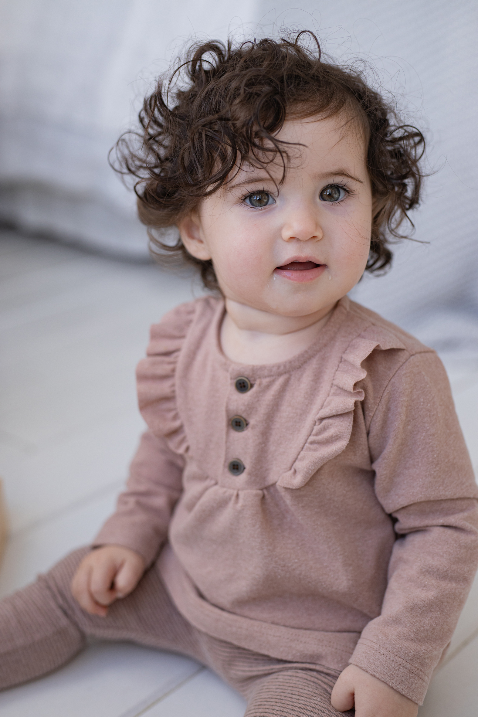 Blouse bébé manches longues en coton rose ancien, modèle Martina de 1+ in the Family, portée par un enfant assis