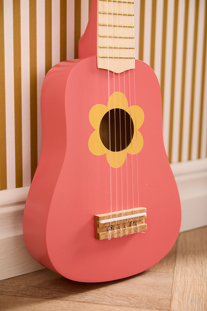 Gros plan sur la guitare Flower Pink avec motif fleur jaune