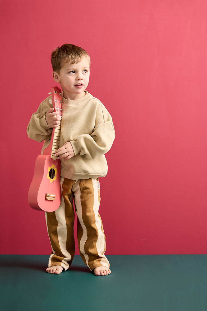 Enfant jouant avec une guitare jouet Flower Pink en bois