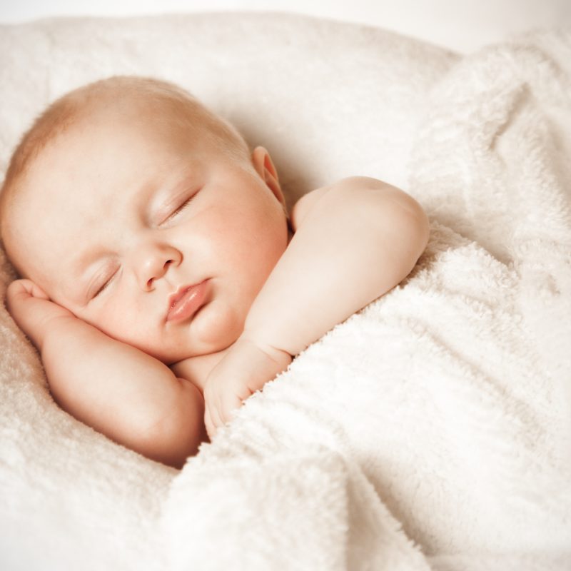 Bébé dormant paisiblement, la tête posée dans sa main