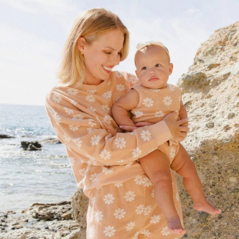 Bébé porté par sa mère en look assorti Rylee + Cru – combinaison éponge à fleurs. Créateurs jouets mode déco