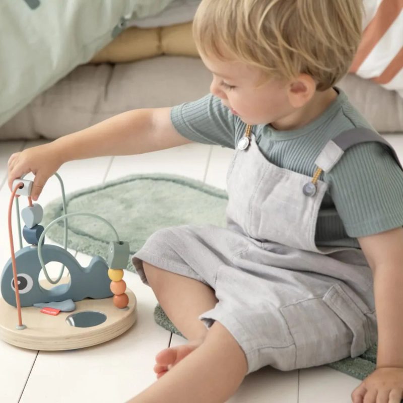 Enfant jouant avec un boulier en bois Wally de Done By Deer pour développer sa motricité fine dès 12 mois