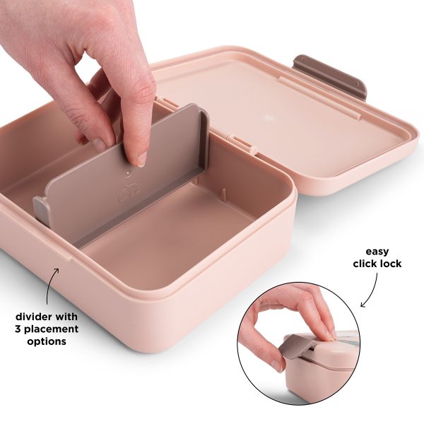 Main ajustant le séparateur amovible dans une boîte à goûter rose Done by Deer avec système de fermeture clic