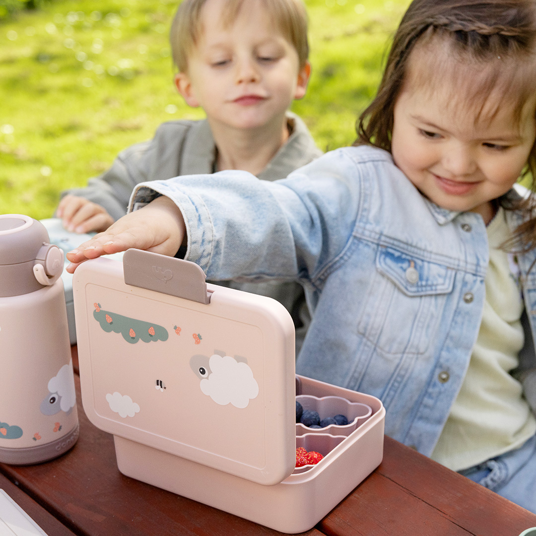 Fillette avec boîte à goûter rose mouton Done by Deer et gourde assortie