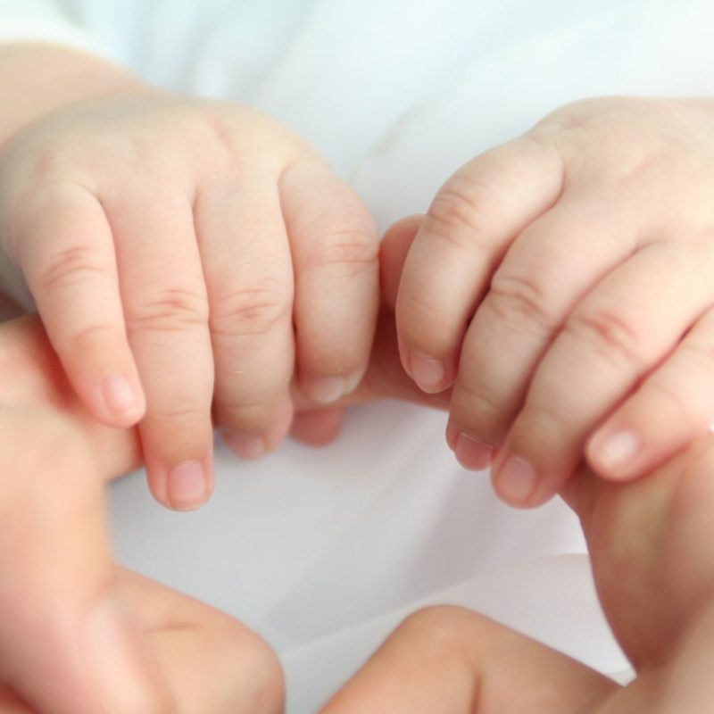 Zoom sur les mains d’un bébé aux ongles courts et bien entretenus