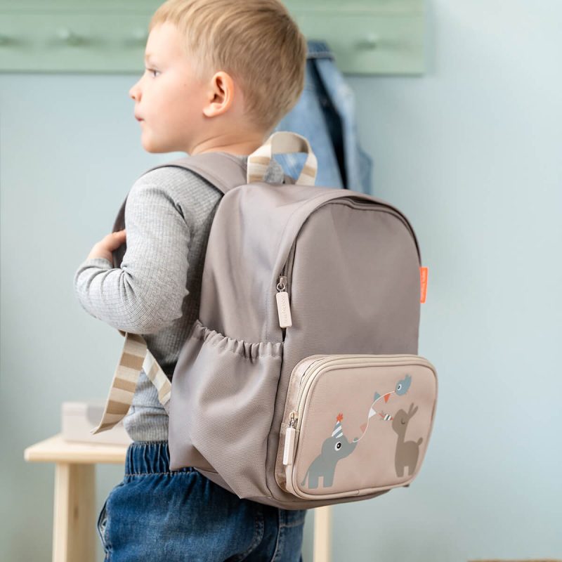 Enfant portant un sac à dos beige Done By Deer décoré d’animaux pour la rentrée en maternelle