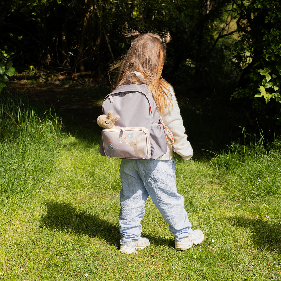 Fille portant un sac à dos maternelle sable Done By Deer avec illustration Elphee et peluche