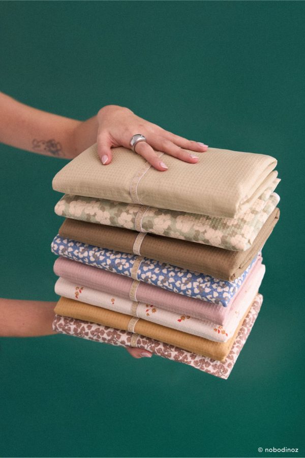 Matelas à langer de voyage Nobodinoz en différents coloris empilés