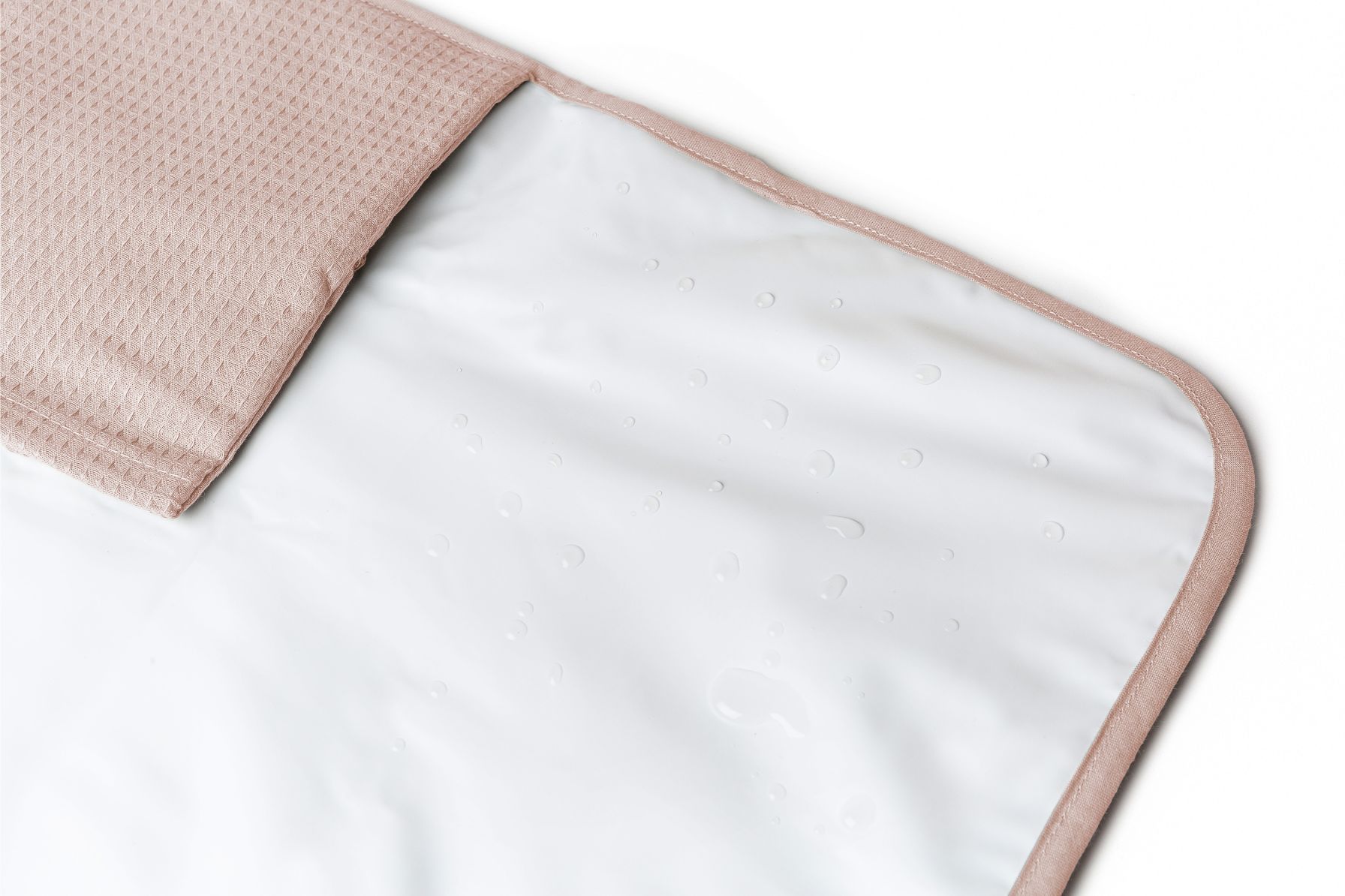 Détail de la doublure imperméable du matelas à langer nomade Nobodinoz rose pâle