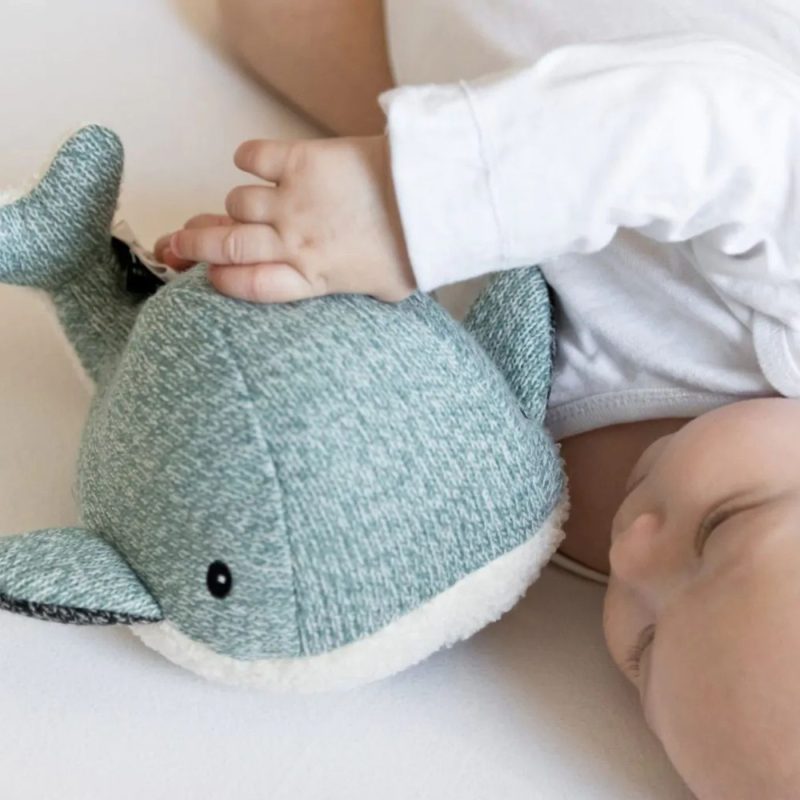 Bébé couché avec une peluche bruit blanc baleine verte