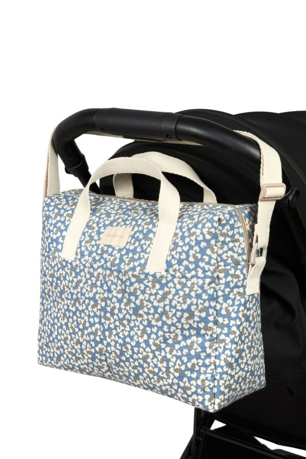 Sac à langer Nobodinoz Gala Opéra Blue Yumiko fixé à une poussette avec ses anses pratiques
