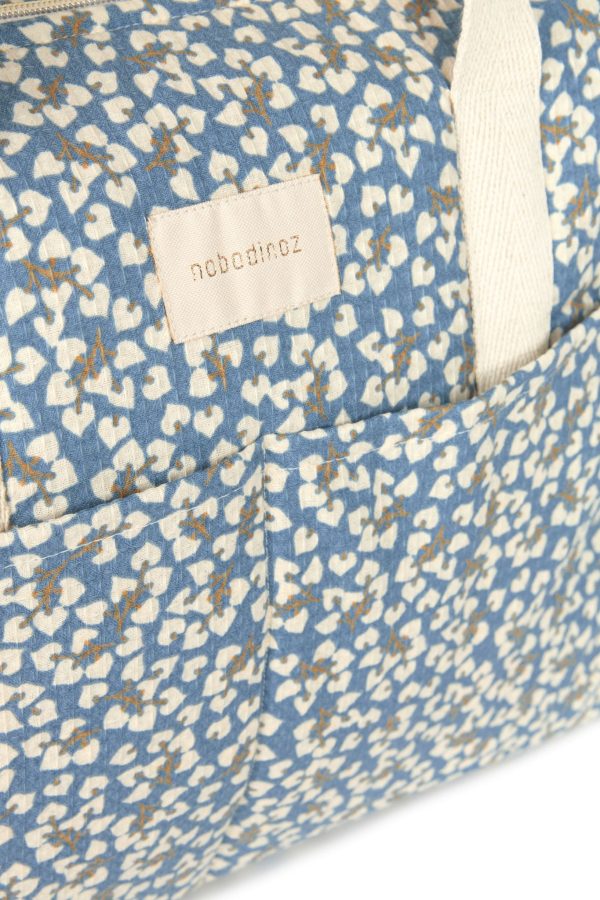 Détail logo Nobodinoz et poche avant du sac à langer imperméable Gala Opéra Blue Yumiko