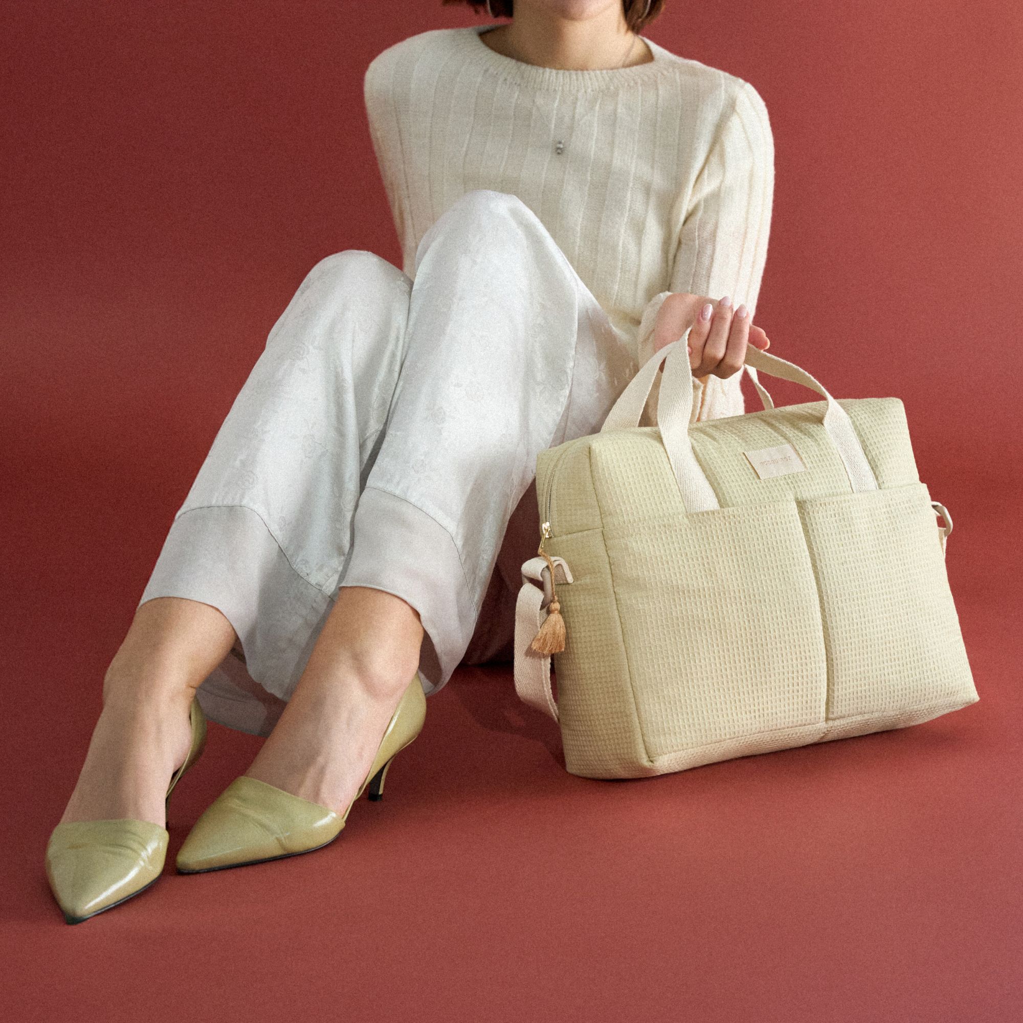 Sac à langer Nobodinoz vert d'eau Gala Opera porté par une femme assise