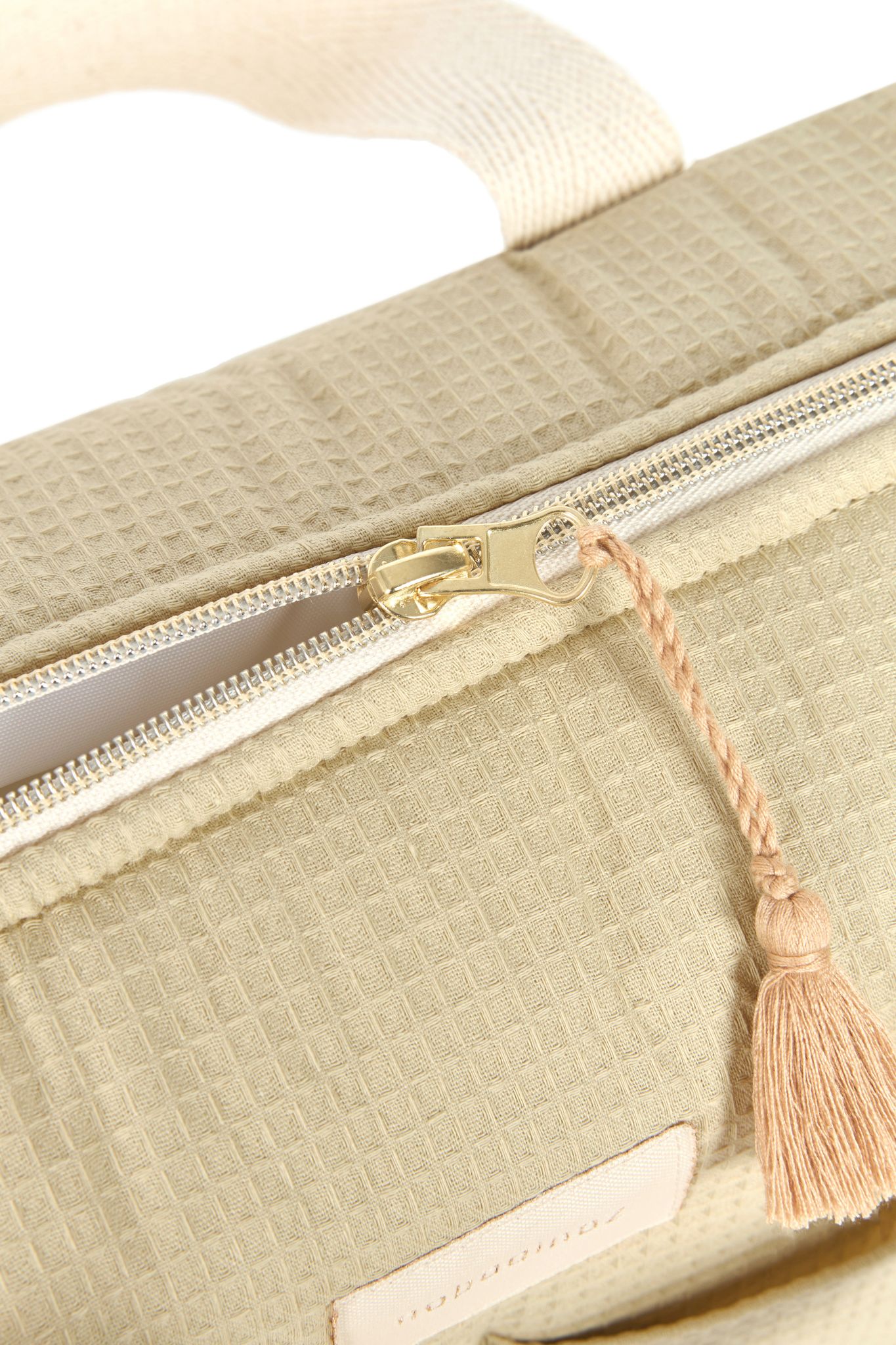 Détail de la fermeture éclair et du pompon sur le sac à langer Nobodinoz vert d'eau