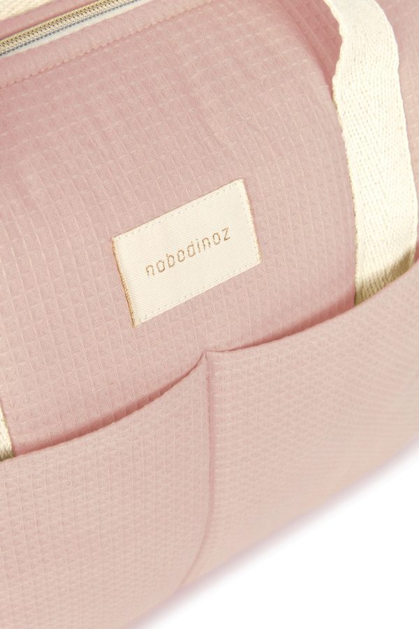 Zoom sur le logo et la poche du sac à langer Nobodinoz Gala rose pâle