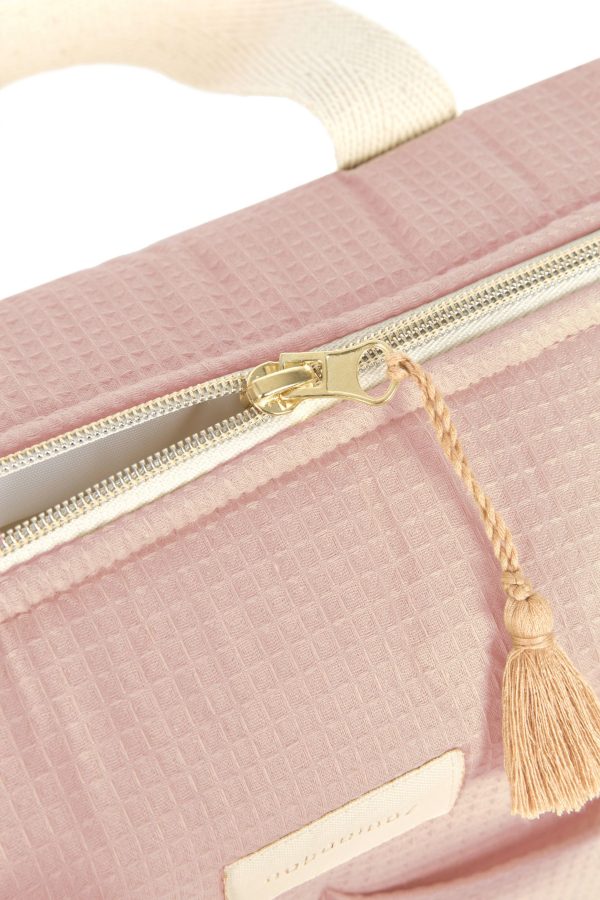 Gros plan sur la fermeture éclair et la pampille en coton bio du sac à langer Nobodinoz rose pâle