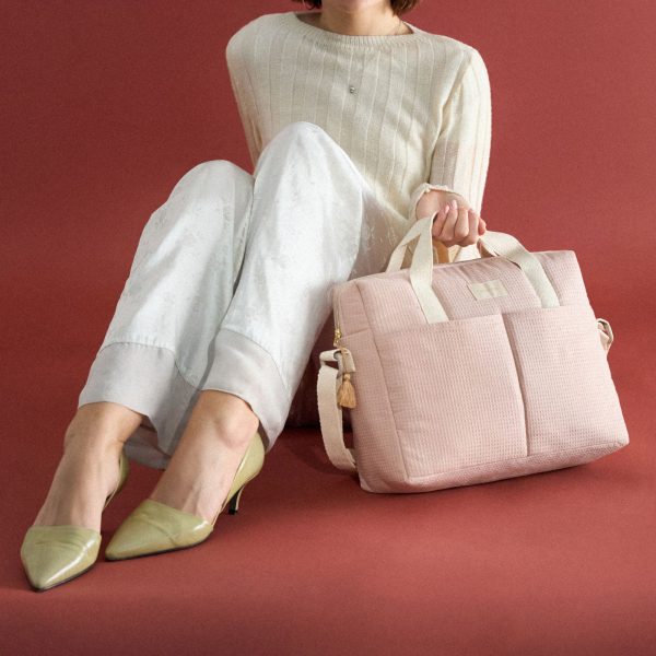 Sac à langer Nobodinoz Gala rose pâle porté à la main