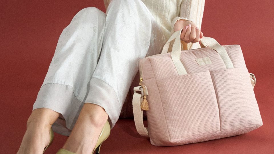 Sac à langer Nobodinoz Gala rose pâle porté à la main