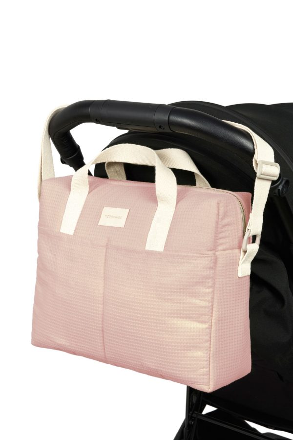 Sac à langer Gala rose pâle Nobodinoz accroché à une poussette