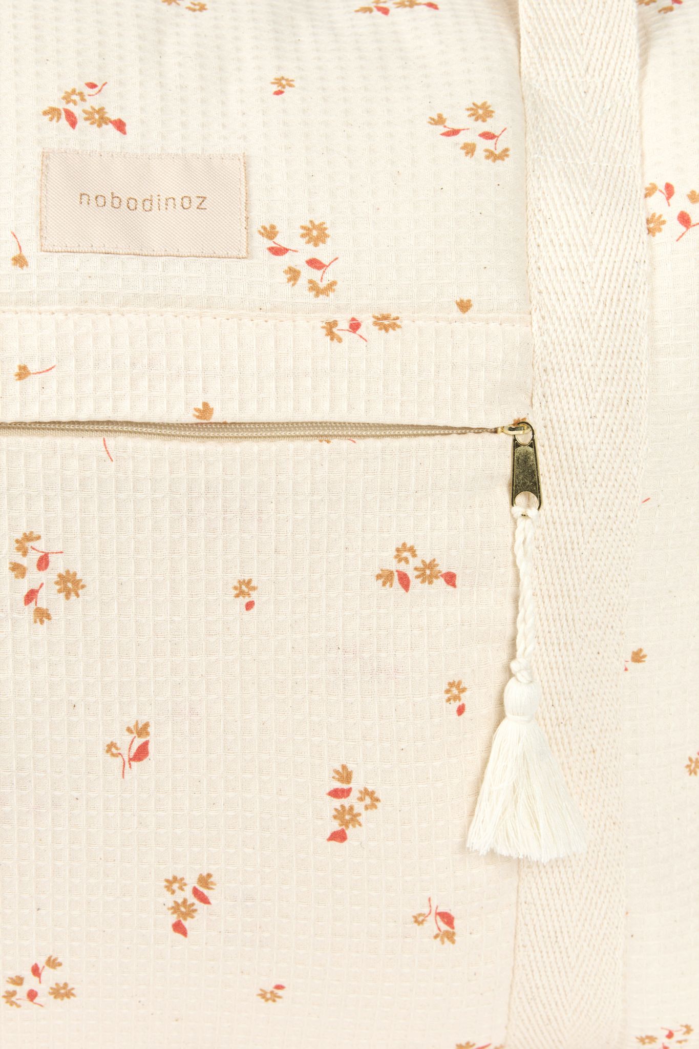 Détail de la poche zippée et tissu du sac à langer Opera yellow lily Nobodinoz