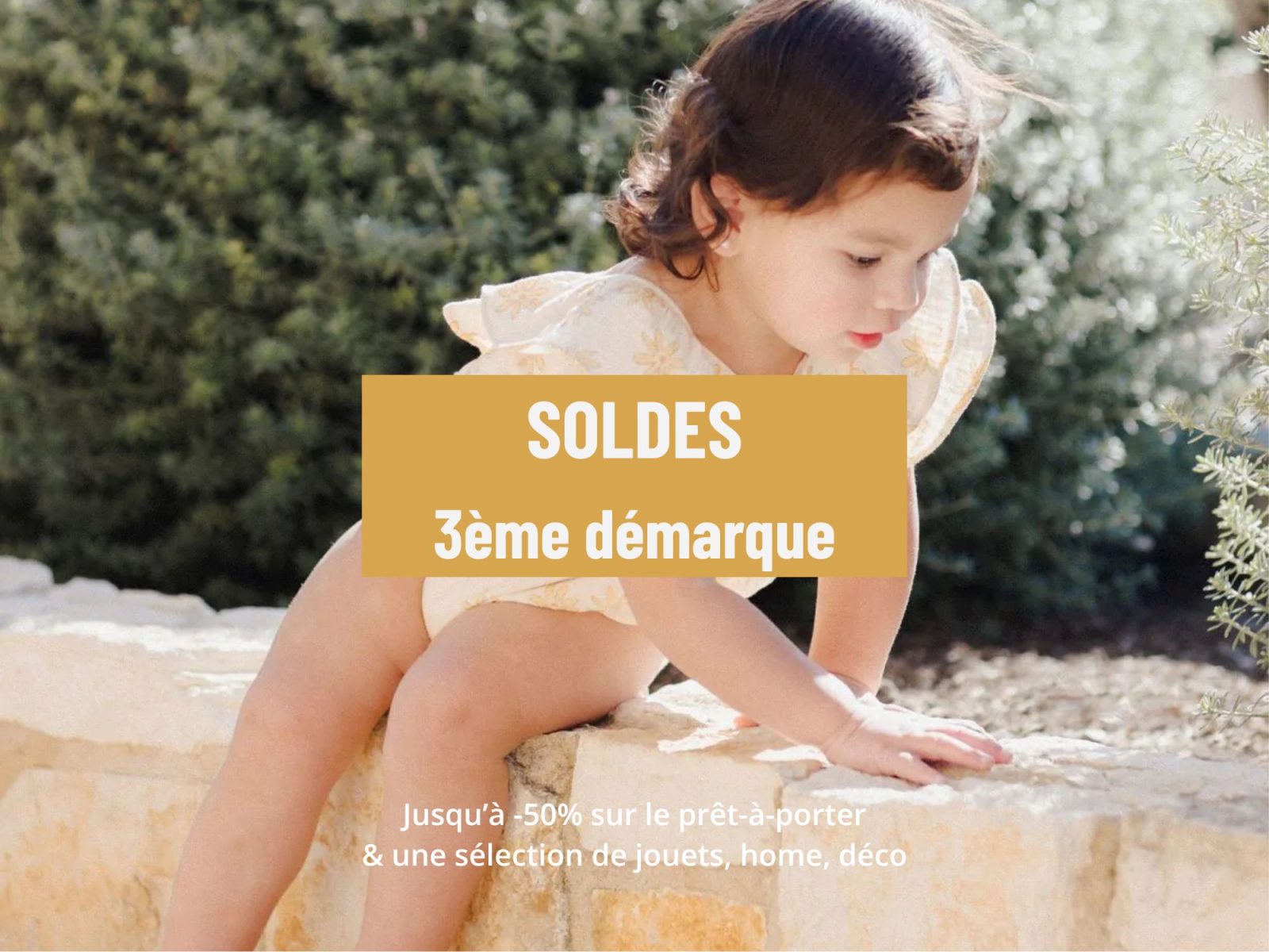 Petite fille en combinaison estivale assise sur un muret pendant les soldes troisième démarque Today is Sunday