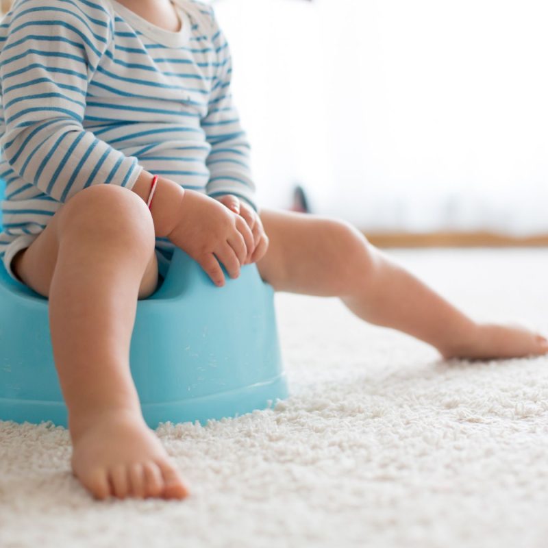 Bébé assis sur un pot bleu – apprentissage de la propreté étape clé.