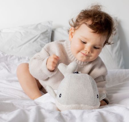 Bébé jouant avec la baleine bruit blanc Flow Amsterdam sur un lit