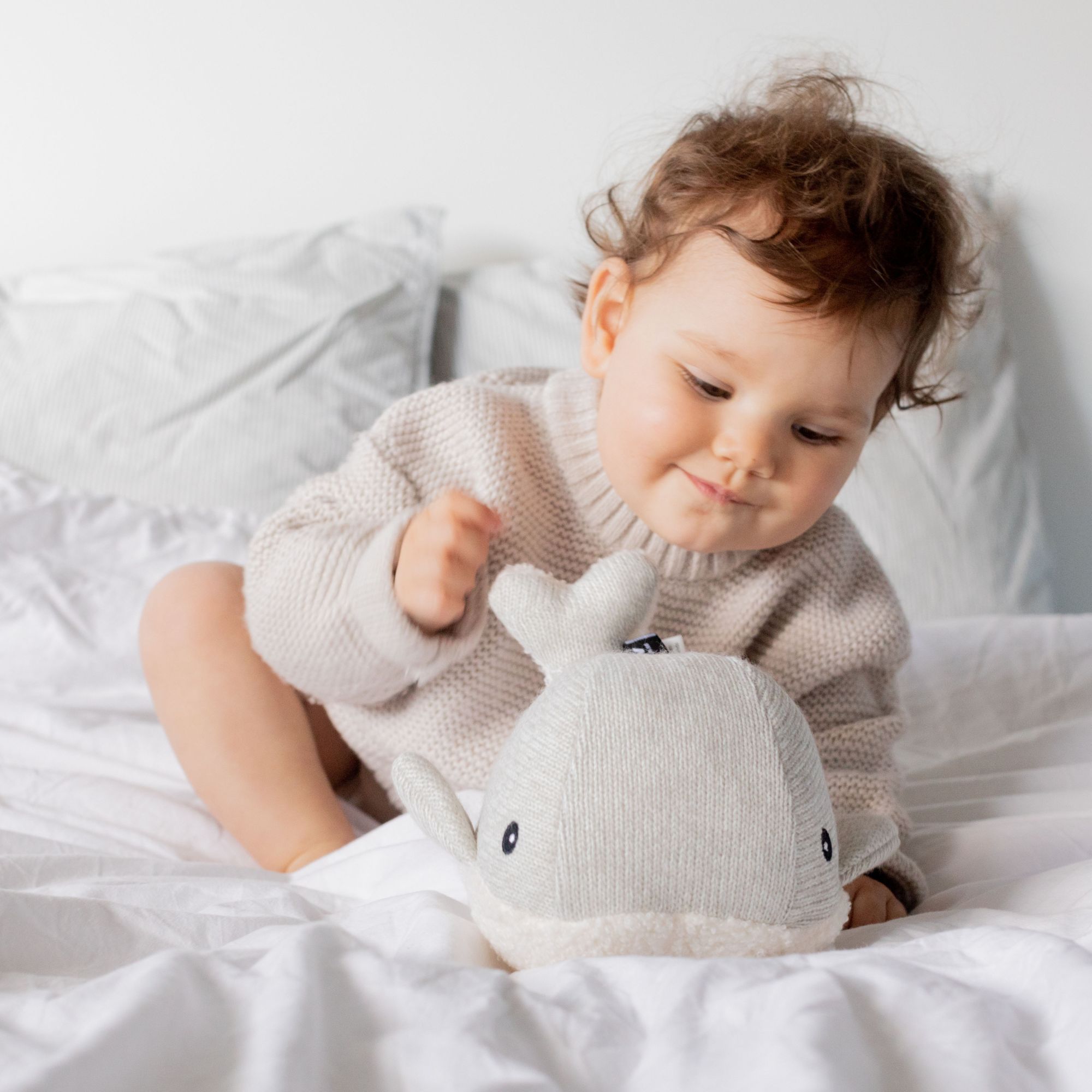 Bébé jouant avec la baleine bruit blanc Flow Amsterdam sur un lit