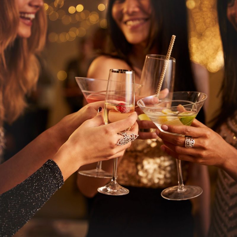 Femmes trinquant avec des verres remplis de cocktails colorés, illustrant l’ambiance festive autour d’un cocktail sans alcool femme enceinte.