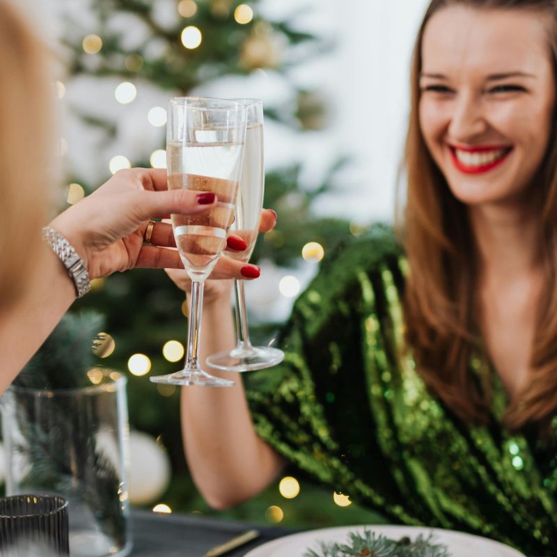 Deux femmes souriantes qui portent un toast avec un cocktail pétillant sans alcool, parfait pour un moment convivial lié au thème cocktail sans alcool femme enceinte.